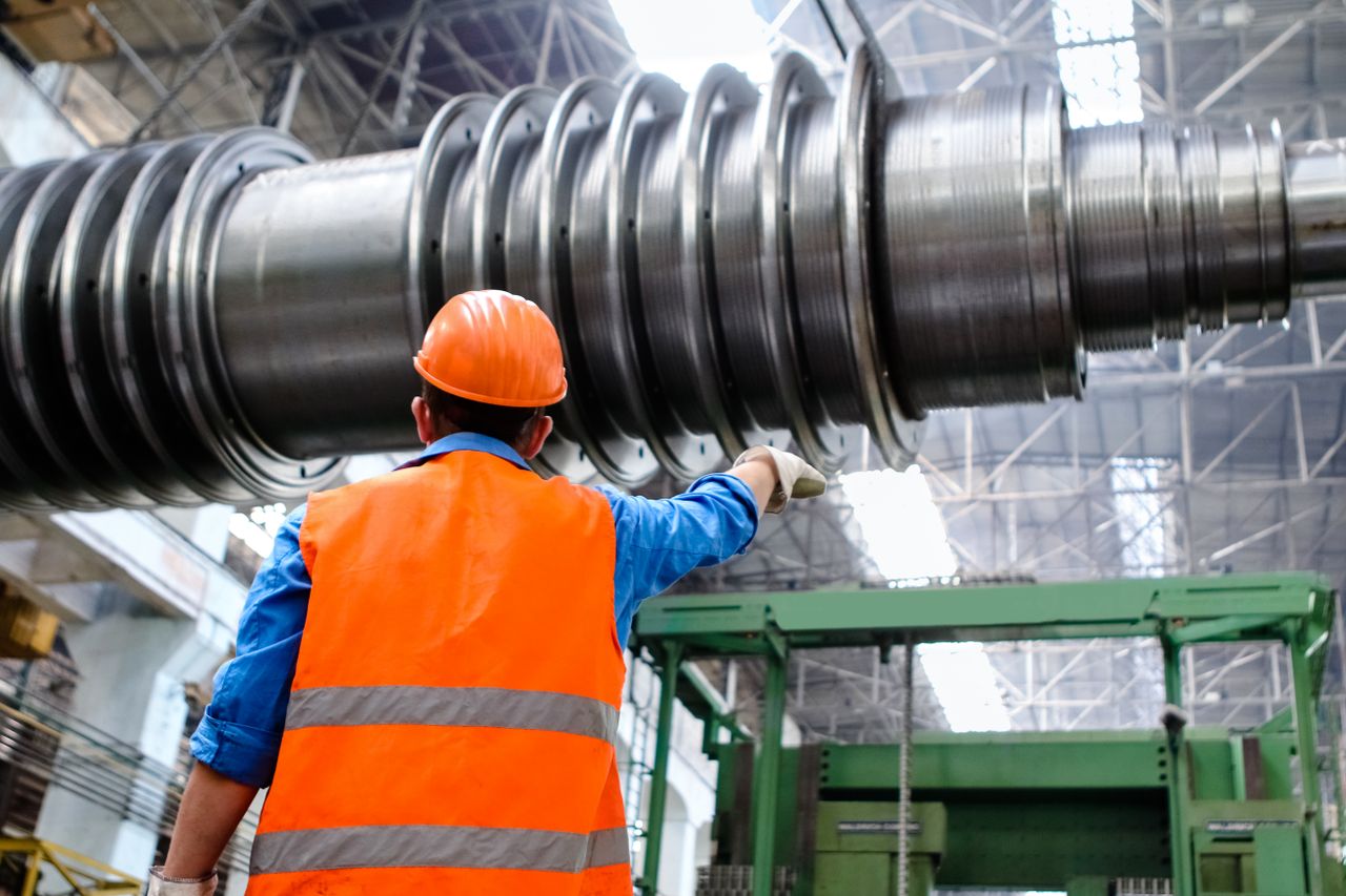 An inspector checking manufactured goods against a specification sheet at a factory